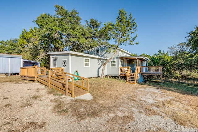 back of house featuring a shed and a wooden deck