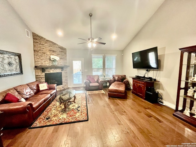 living room with light hardwood / wood-style floors, high vaulted ceiling, a fireplace, and ceiling fan