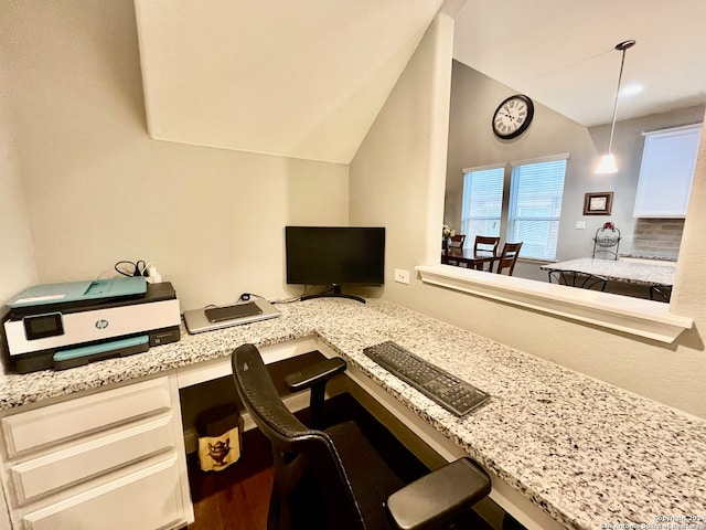 office space featuring hardwood / wood-style flooring, built in desk, and vaulted ceiling