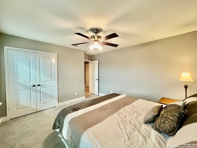 bedroom featuring a closet, ceiling fan, and light colored carpet