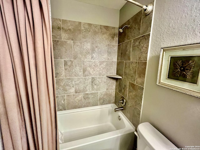 bathroom with shower / bath combination with curtain and toilet