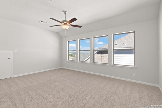 carpeted empty room with plenty of natural light, lofted ceiling, and ceiling fan