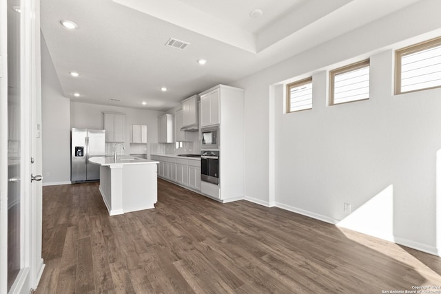 kitchen featuring a center island, sink, stainless steel appliances, dark hardwood / wood-style floors, and decorative backsplash