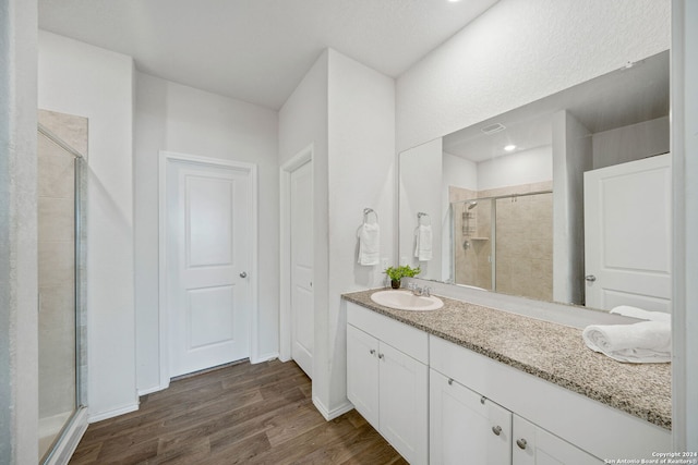 bathroom with vanity, hardwood / wood-style floors, and a shower with shower door