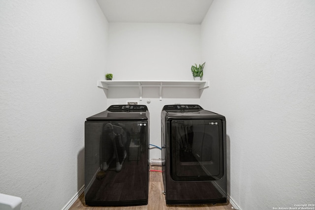 washroom with independent washer and dryer and light wood-type flooring