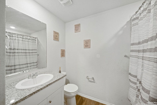 bathroom featuring vanity, hardwood / wood-style floors, and toilet