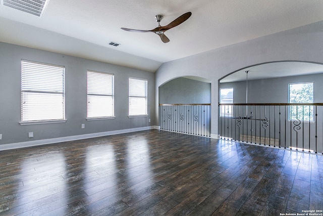 spare room with ceiling fan, a healthy amount of sunlight, and dark hardwood / wood-style floors