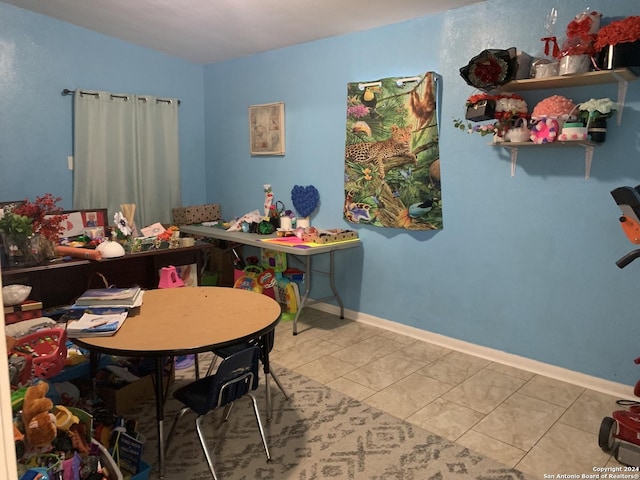recreation room featuring lofted ceiling and baseboards
