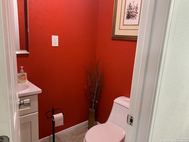 half bathroom featuring vanity and toilet