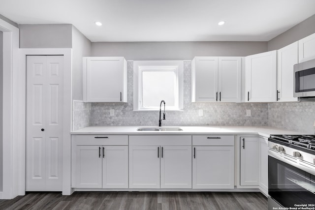 kitchen with white cabinetry, appliances with stainless steel finishes, sink, and dark wood-type flooring