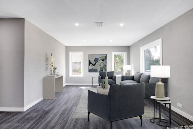 living room with a healthy amount of sunlight and dark wood-type flooring