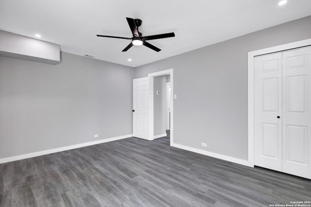 unfurnished bedroom with dark hardwood / wood-style flooring, a closet, and ceiling fan