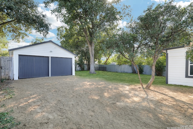 view of yard featuring a garage and an outdoor structure