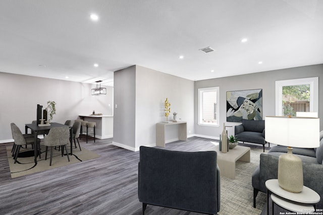 living room with a notable chandelier and dark wood-type flooring