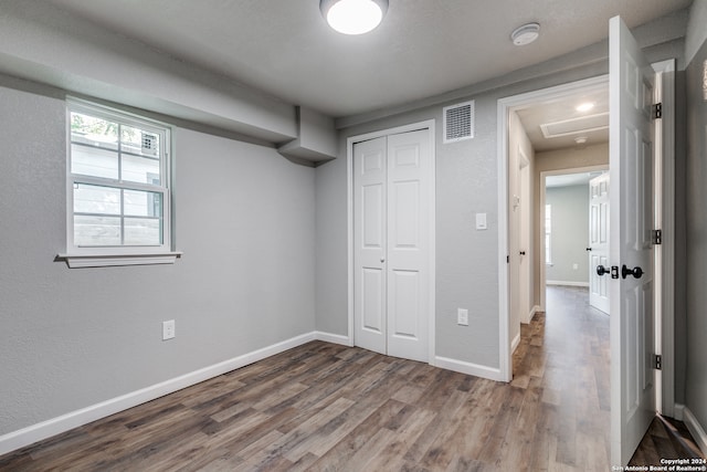 unfurnished bedroom featuring hardwood / wood-style floors and a closet