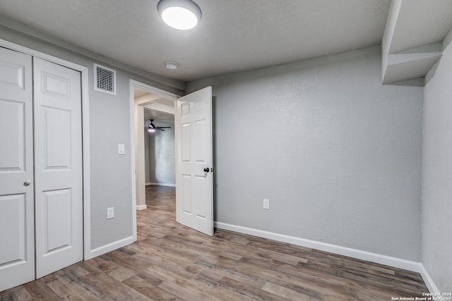 unfurnished bedroom with hardwood / wood-style flooring and a closet