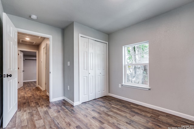 unfurnished bedroom featuring hardwood / wood-style flooring and a closet