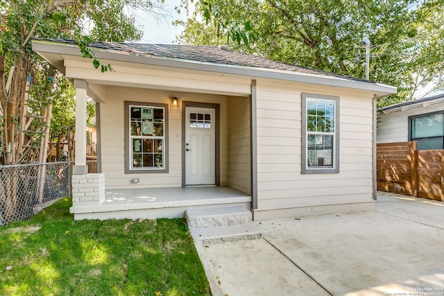 entrance to property featuring a yard and a porch