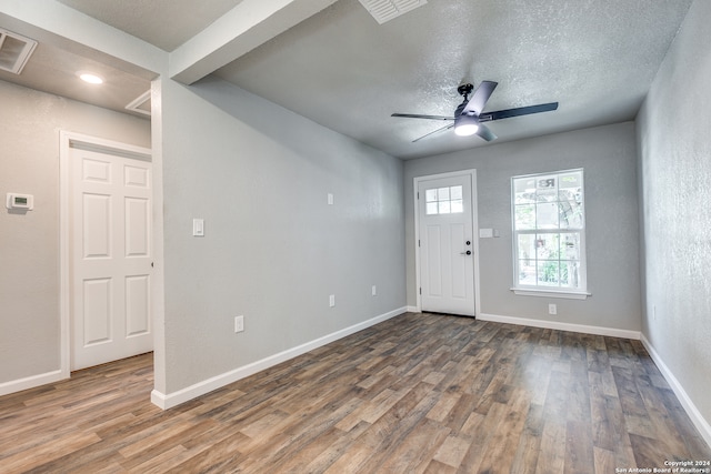 foyer entrance with dark wood-type flooring, ceiling fan, and a textured ceiling