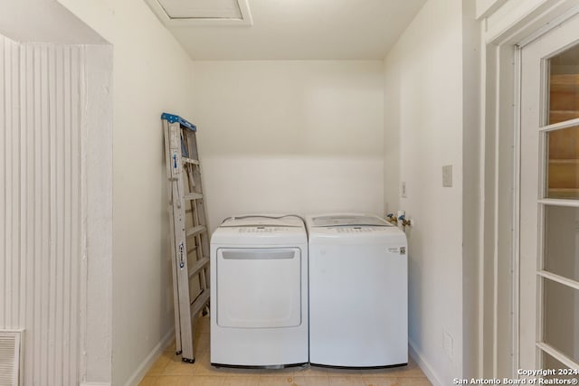 washroom with washing machine and dryer and light tile patterned floors