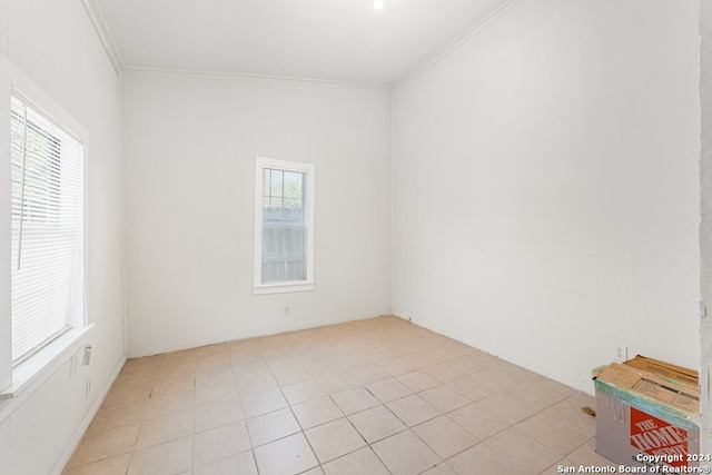 empty room with ornamental molding and light tile patterned flooring