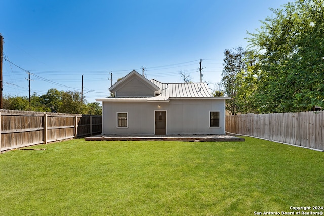 rear view of property featuring a patio area and a lawn