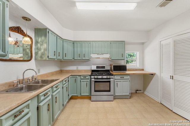 kitchen with sink, appliances with stainless steel finishes, and decorative light fixtures