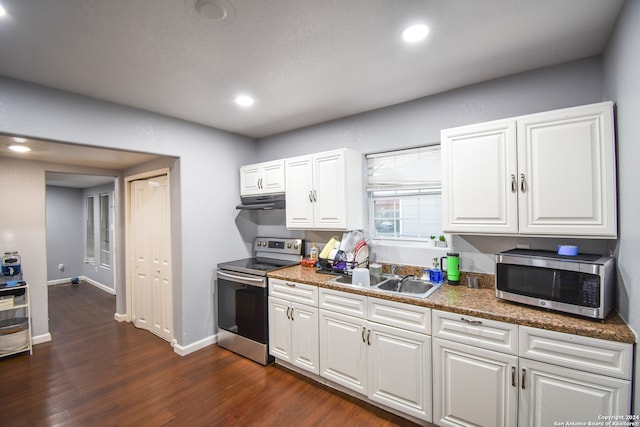 kitchen with white cabinets, dark stone countertops, dark wood-type flooring, sink, and stainless steel appliances