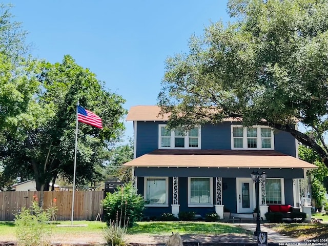 view of front of home featuring a porch and fence