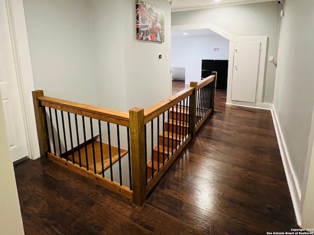 hall with wood finished floors, an upstairs landing, and baseboards