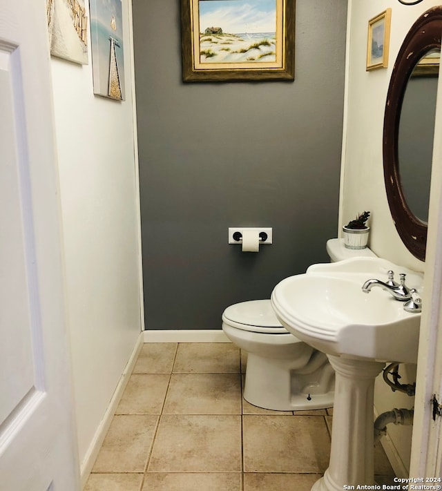 bathroom featuring tile patterned floors, baseboards, and toilet