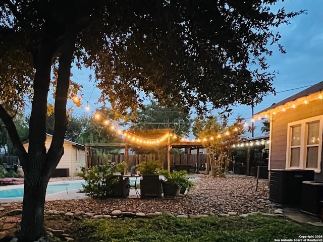 view of yard featuring a fenced backyard, an outdoor pool, and central AC