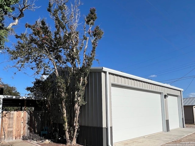 detached garage featuring fence