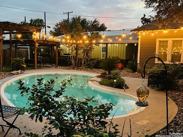 pool at dusk featuring a patio and an outdoor pool