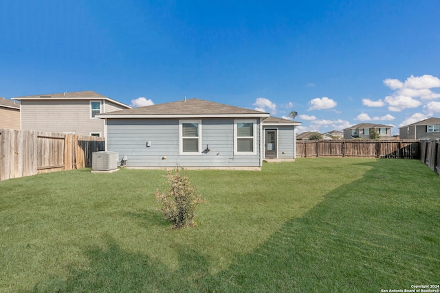 rear view of house with a yard and central air condition unit