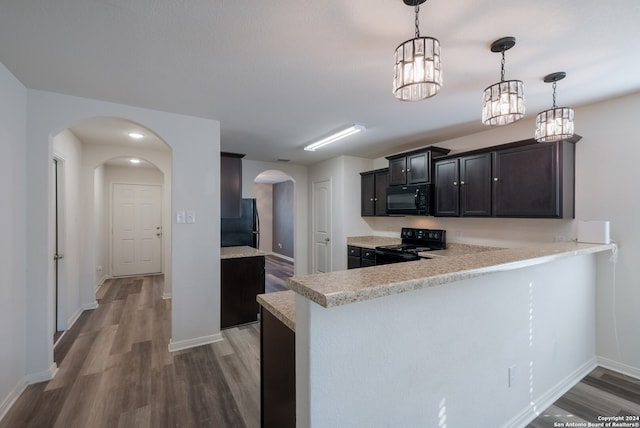 kitchen with kitchen peninsula, black appliances, hanging light fixtures, and dark hardwood / wood-style flooring