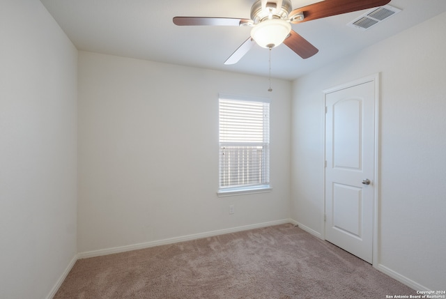 empty room featuring light colored carpet and ceiling fan