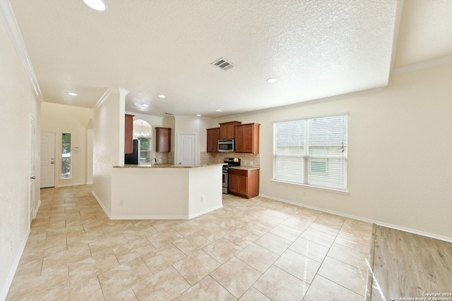 kitchen with tasteful backsplash, light tile patterned floors, a textured ceiling, crown molding, and stainless steel appliances