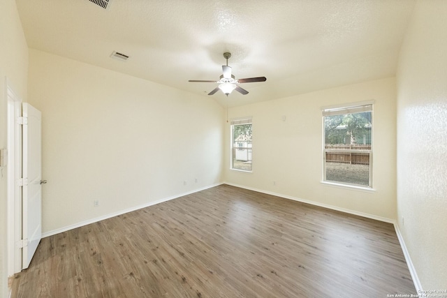 empty room with ceiling fan, hardwood / wood-style flooring, and a textured ceiling