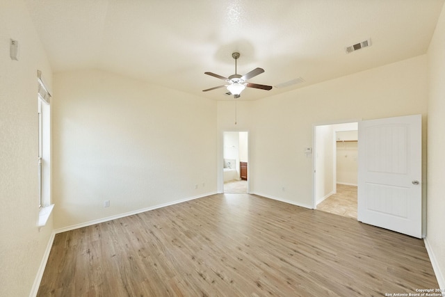 spare room featuring lofted ceiling, light wood-type flooring, and ceiling fan