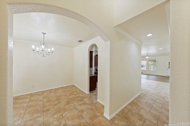 interior space featuring a notable chandelier, a textured ceiling, and crown molding