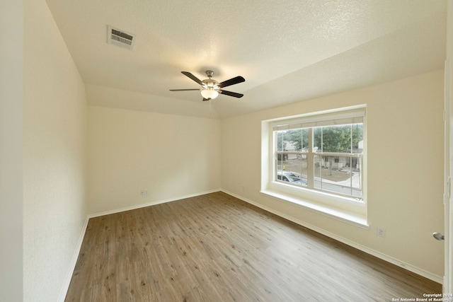 spare room featuring a textured ceiling, hardwood / wood-style flooring, and ceiling fan