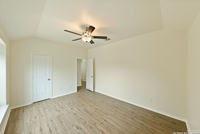 unfurnished bedroom featuring ceiling fan, a textured ceiling, lofted ceiling, and light wood-type flooring