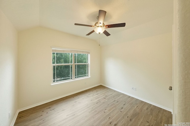 empty room with lofted ceiling, light hardwood / wood-style floors, and ceiling fan