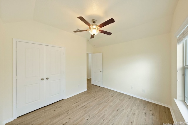 unfurnished bedroom featuring a closet, light hardwood / wood-style floors, lofted ceiling, and ceiling fan