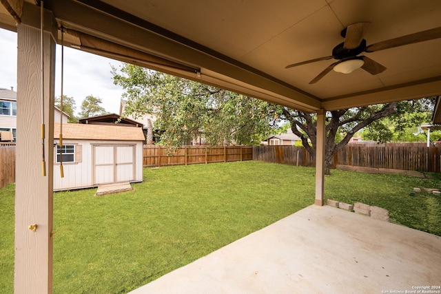 view of yard featuring a shed, a patio area, and ceiling fan