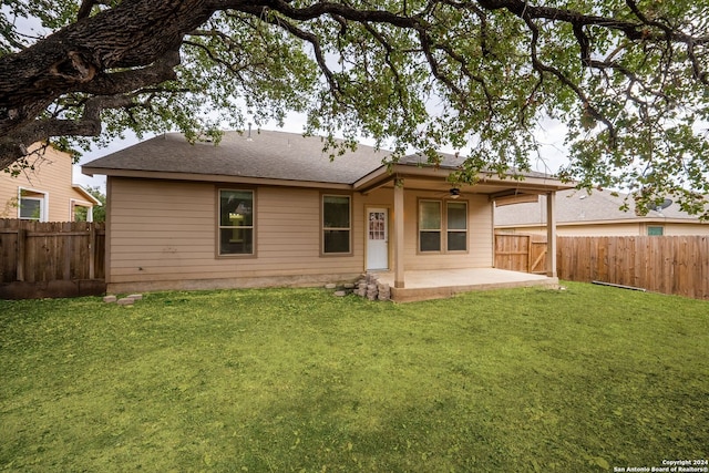 rear view of property featuring a yard and a patio area