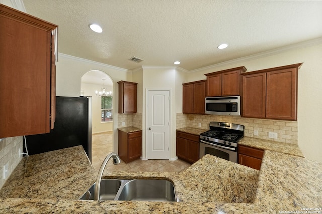 kitchen featuring kitchen peninsula, a textured ceiling, sink, crown molding, and stainless steel appliances