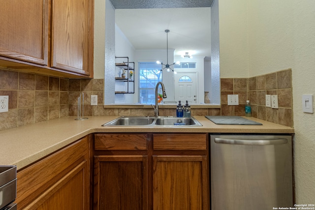 kitchen featuring dishwasher, a chandelier, sink, and backsplash