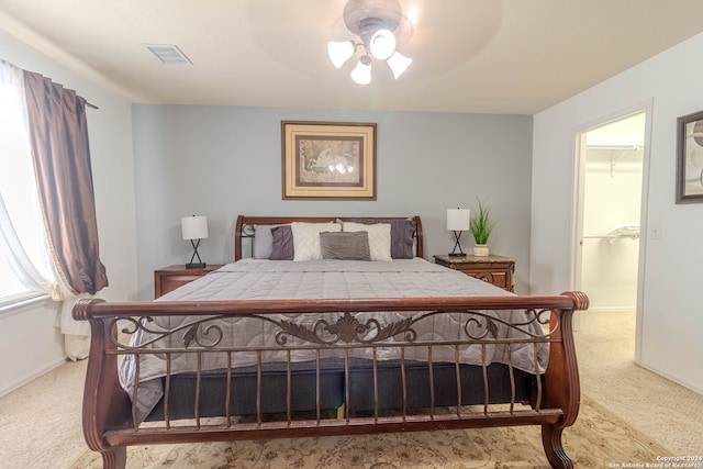 carpeted bedroom featuring a spacious closet, a closet, and ceiling fan